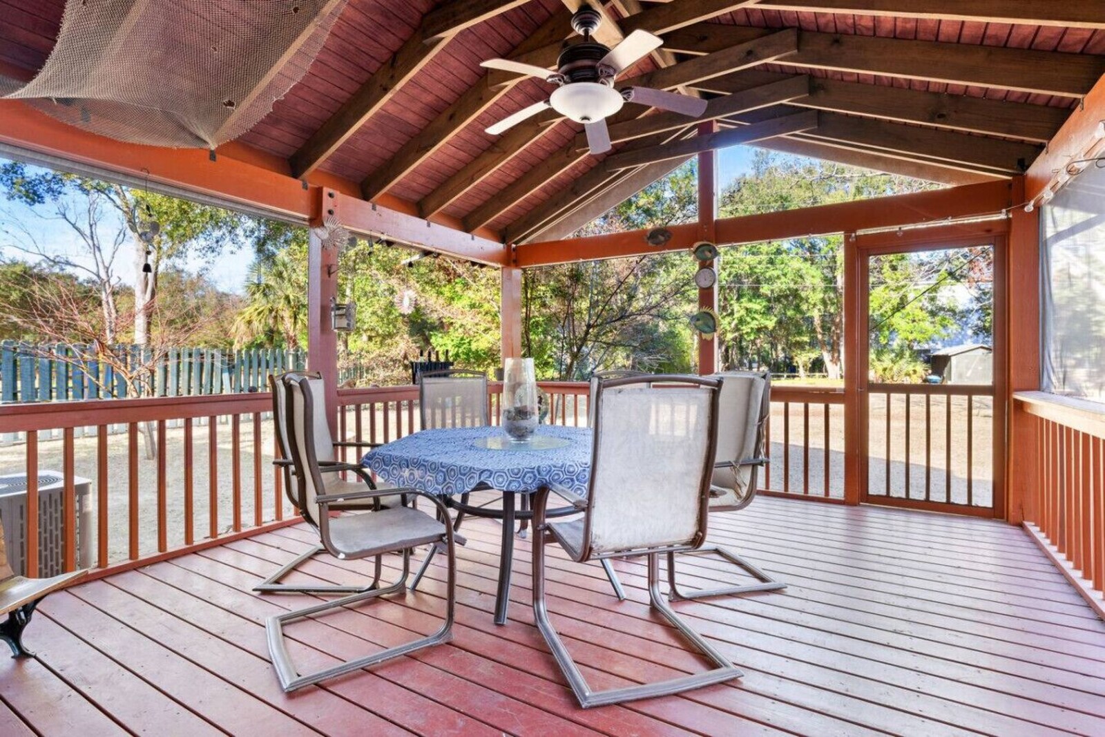 Screened back porch overlooking the large backyard at the Folly Beach Getaway house